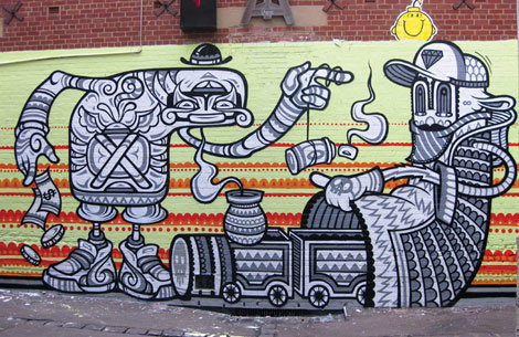 A black and white mural on a colourful wall depicts two stylised figures. One figure holds a banknote and gestures towards the other, who wears a cap and sits atop a small train.