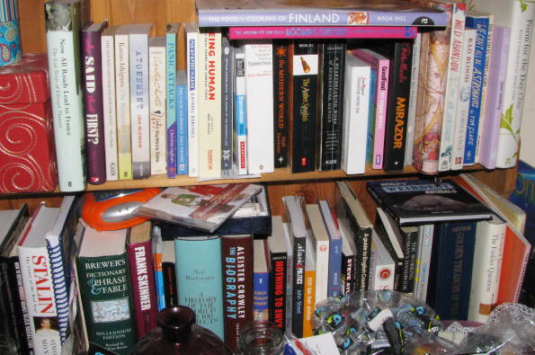 A crowded bookshelf filled with a diverse collection of books. Legible titles include “Stalin”, “Brewers Dictionary of Phrase & Fable” and “The Biography”.