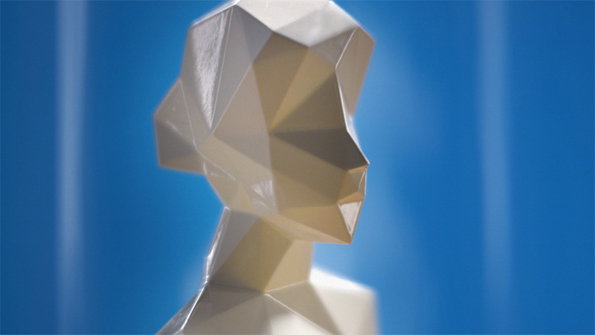 A 3D render of a low-poly human head and shoulders in a pale, off-white tone. The angular figure is set against a deep blue background with soft vertical light streaks.