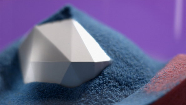 A white, faceted geometric shape rests on a mound of blue powder. The scene is set against a plain purple background.