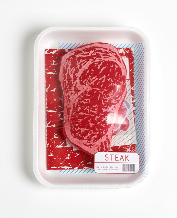 A red fabric steak sits inside a white polystyrene tray, wrapped in clear plastic. A white label at the bottom reads “STEAK” and “Lewis Wade Stringer”.