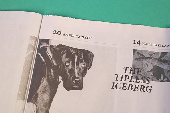 An open magazine page features a black and white photograph of a dog looking at the camera. To the right, a bold headline reads “THE TIPLESS ICEBERG”.