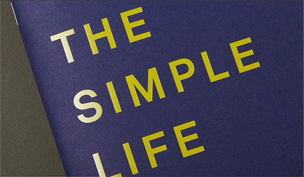 Yellow text on a dark blue background reads “THE SIMPLE LIFE”. The words are arranged in three lines and angled across the frame.