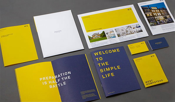 A collection of brand identity materials in yellow, navy blue and white. A navy blue booklet reads “WELCOME TO THE SIMPLE LIFE”, while an open yellow brochure reads “PREPARATION IS HALF THE BATTLE”.