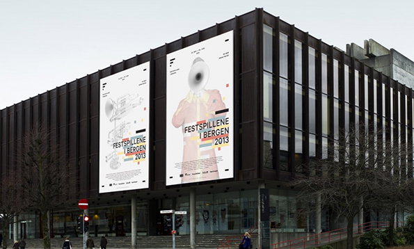 Two large vertical banners hang from the side of a brown, ribbed building. They feature a stylised figure and the text “Festspillene i Bergen 2013”.