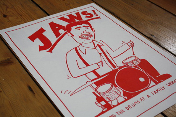A red and white illustration of a person playing a drum kit. Above them, bold text reads “JAWS!”, while text at the bottom reads “THE DRUMS AT A FAMILY WEDDIN”.