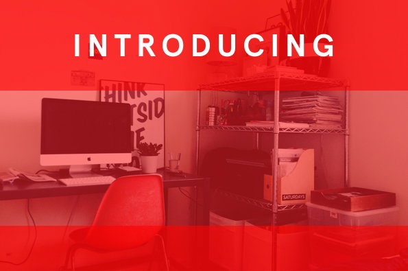 A home office setup with a computer on a desk and a metal shelving unit filled with papers. The image is overlaid with a red gradient and the word “INTRODUCING” in white capitals.