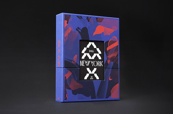 A blue and red patterned box features a central black square with a white graphic. The graphic includes the words “IMG” and “NEW YORK” alongside a stylised star shape.