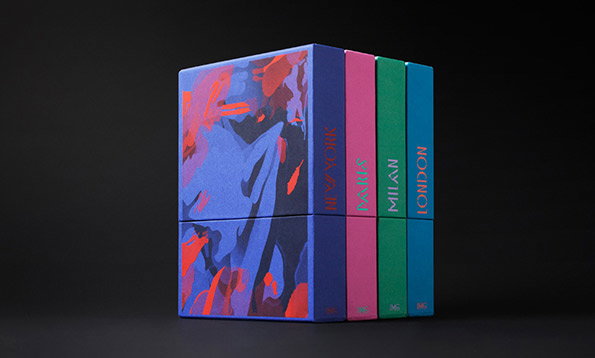Four colourful, square boxes are stacked in two rows of two. The boxes are blue, pink, green and teal, with the spines reading “New York”, “Paris”, “Milan” and “London”.