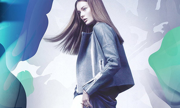 A person with long, flowing hair wears a structured blue leather jacket. They are set against a pale background layered with abstract, translucent shapes in blue and green.