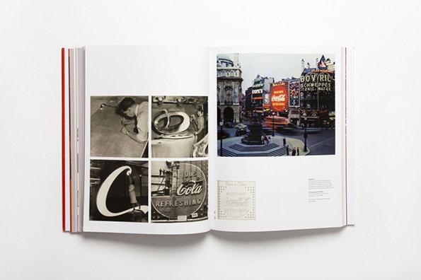 An open book displays a collection of black and white photographs. One page shows a grid of four images, including a person leaning on a table and a “Coca-Cola” sign. The opposite page features a wide shot of a city square filled with bright neon billboards.