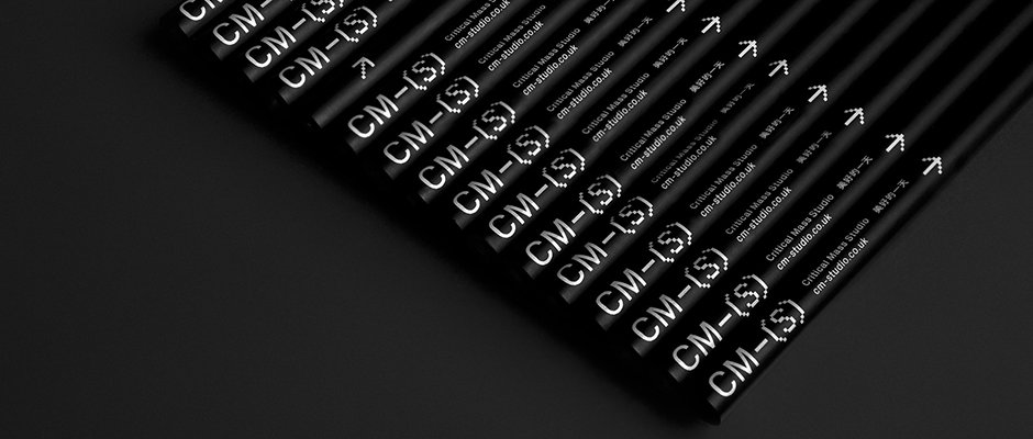 A row of black pencils laid diagonally across a dark surface. Each pencil is printed with the white text “CM-(S)”, “Critical Mass Studio” and the website “cm-studio.co.uk”.