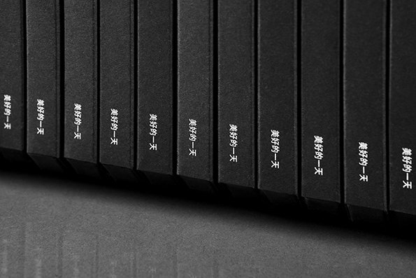 A row of identical black book spines stands side by side. Each spine features the same short phrase in white Chinese characters.