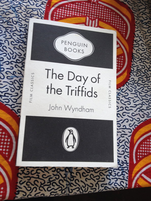 A copy of the book The Day of the Triffids by John Wyndham. The white cover features black bands at the top and bottom, with the “Penguin Books” logo and a penguin icon.