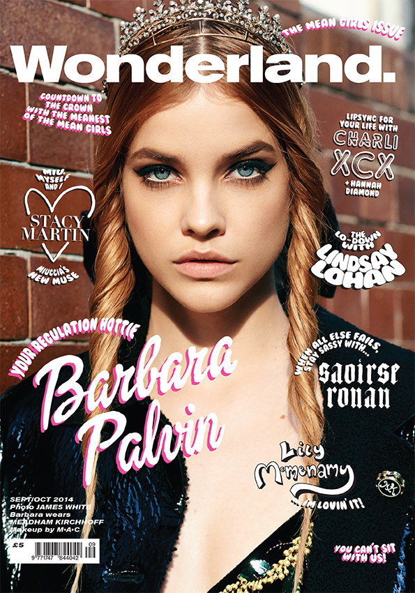 Barbara Palvin looks directly at the camera on the cover of Wonderland magazine. She wears a sparkling tiara and has her hair in two long braids. The cover is titled “The Mean Girls Issue” and features headlines for Charli XCX, Lindsay Lohan, Saoirse Ronan and Lily McMenamy. The name “Barbara Palvin” is written in large, pink cursive text across the centre.