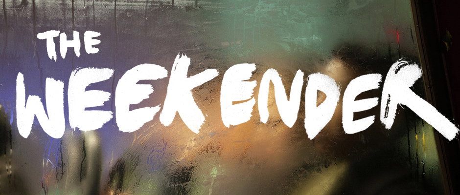 White, hand-painted text reads “THE WEEKENDER” across a rain-streaked window. Blurred lights and dark shapes are visible through the glass in the background.