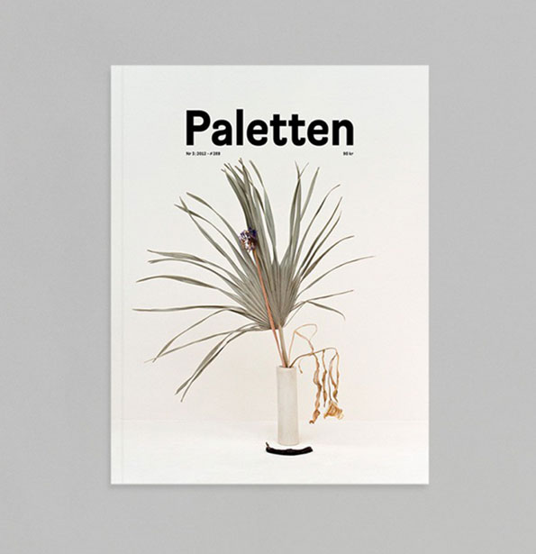 The cover of a magazine titled “Paletten”. A single, spindly green plant with long leaves sits in a slender white vase against a plain white background.