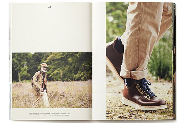 An open magazine spread. On the left, a person in outdoor clothing walks through a field of purple heather. On the right, a close-up shows a pair of brown leather hiking boots and cuffed trousers.