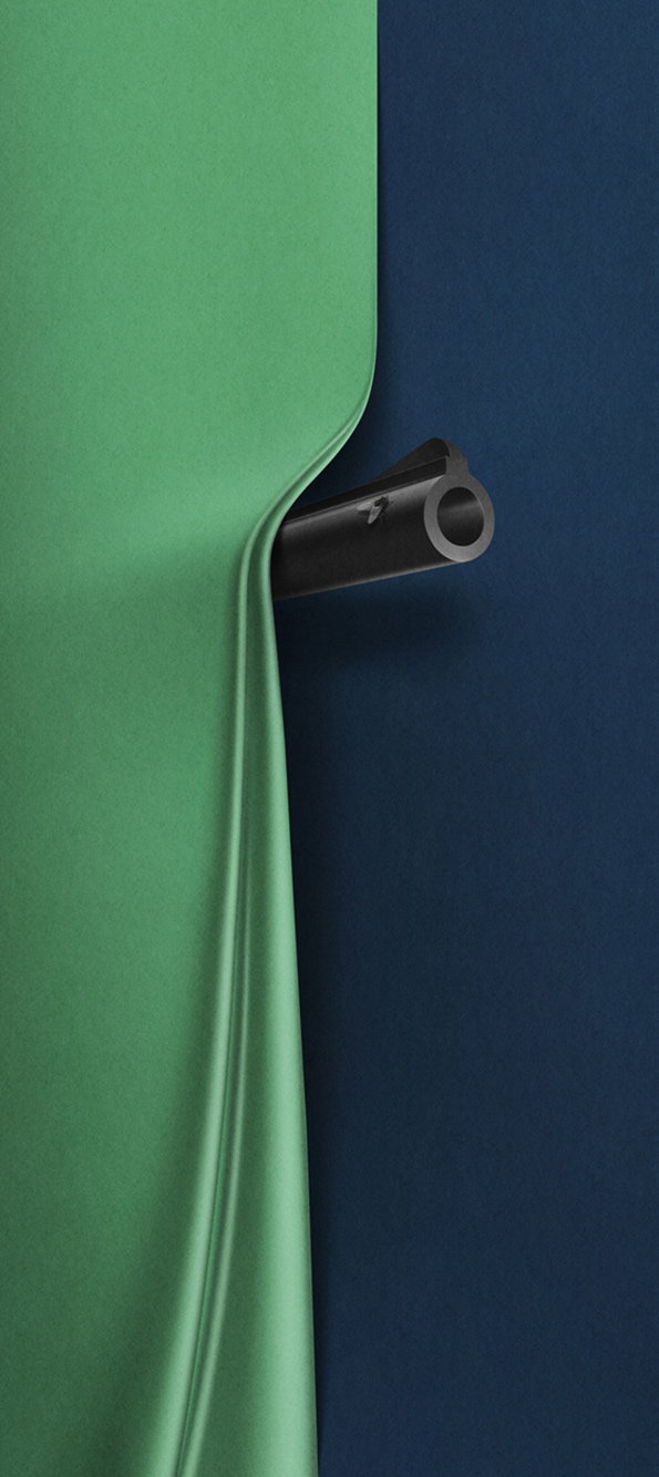 A 3D render of a black tubular object pushing through a sheet of green fabric. The fabric stretches and curves around the object against a dark blue background.