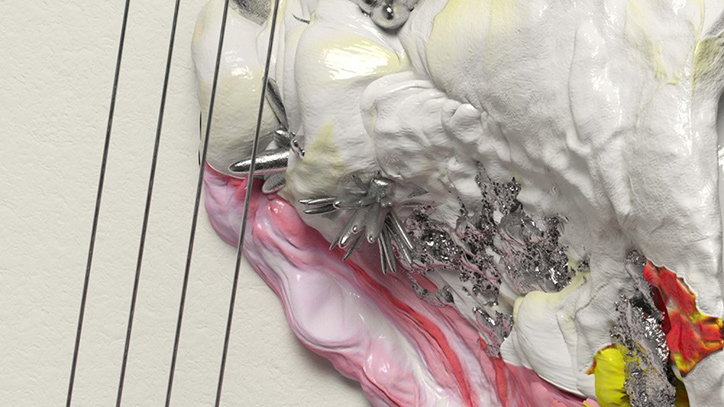 A close-up of a white, organic sculpture with a glossy, undulating surface. Metallic, spike-like forms emerge from the form, which transitions into swirls of pink, red and yellow.