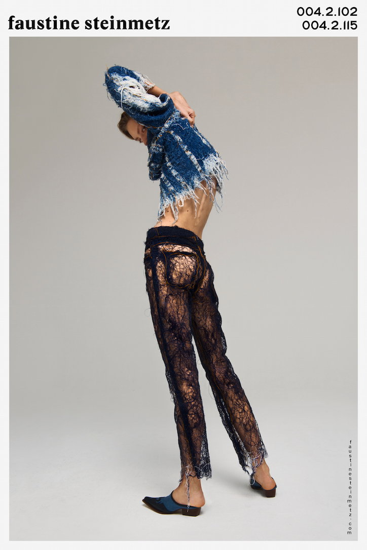 A person poses in profile, wearing a frayed blue denim jacket and sheer, dark lace trousers. They lean back with their arms raised above their head. Above the image, text reads “faustine steinmetz” and “004.2.102 004.2.115”.