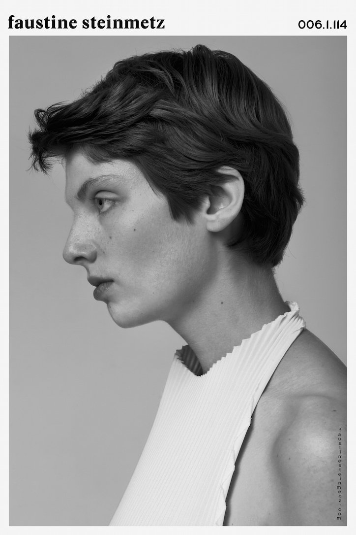 A black and white profile portrait of a person with short, dark hair. They wear a white, pleated garment and look off-camera against a plain background. The name “faustine steinmetz” and the number “006.I.114” appear at the top.