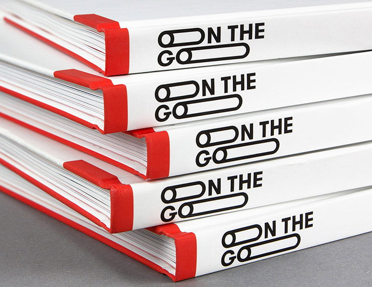 A stack of five white books with red spines. The spines feature a black graphic and the words “ON THE GO”.