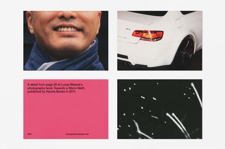 Four printed cards arranged in a grid. They show a close-up of a person smiling, the rear of a white car, a black-and-white abstract image, and a pink card with text. The pink card reads “A detail from page 25 of Lucas Blalock’s photography book Towards a Warm Math, published by Hassla Books in 2011.”