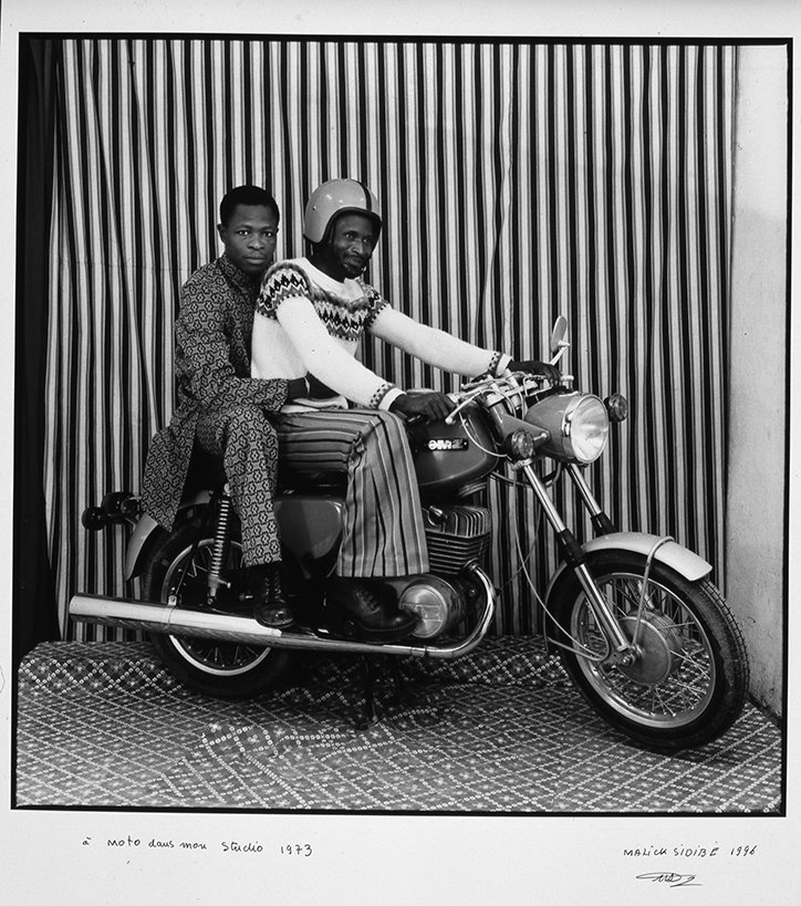 05_PressImage-MUL-l-Malick-Sidibé_-On-the-motorbike-in-my-studio_-1973.jpg