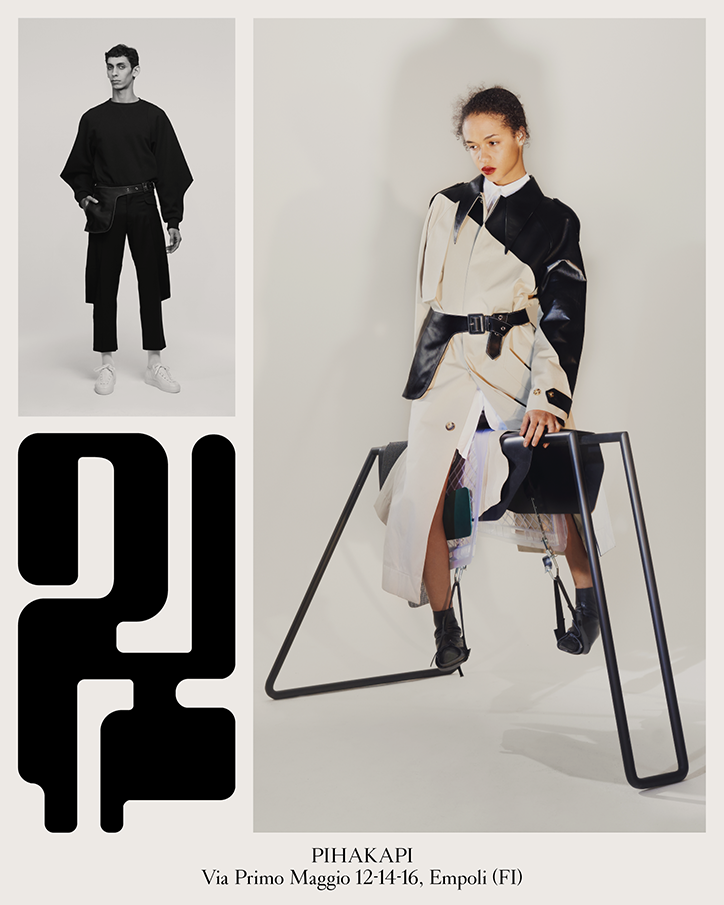 A fashion lookbook featuring two people in structured, monochrome clothing. One person wears a black oversized top and trousers, while the other wears a cream and black coat with a wide belt. Bold, abstract black shapes and the text “PIHAKAPI” and an address in Empoli, Italy, appear on the page.