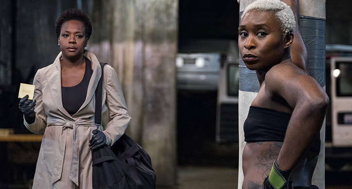 Two side-by-side images of Viola Davis in different roles. On the left, she wears a beige trench coat and black gloves, holding a small card. On the right, she has short bleached hair and wears a black sports top, leaning against a concrete pillar.