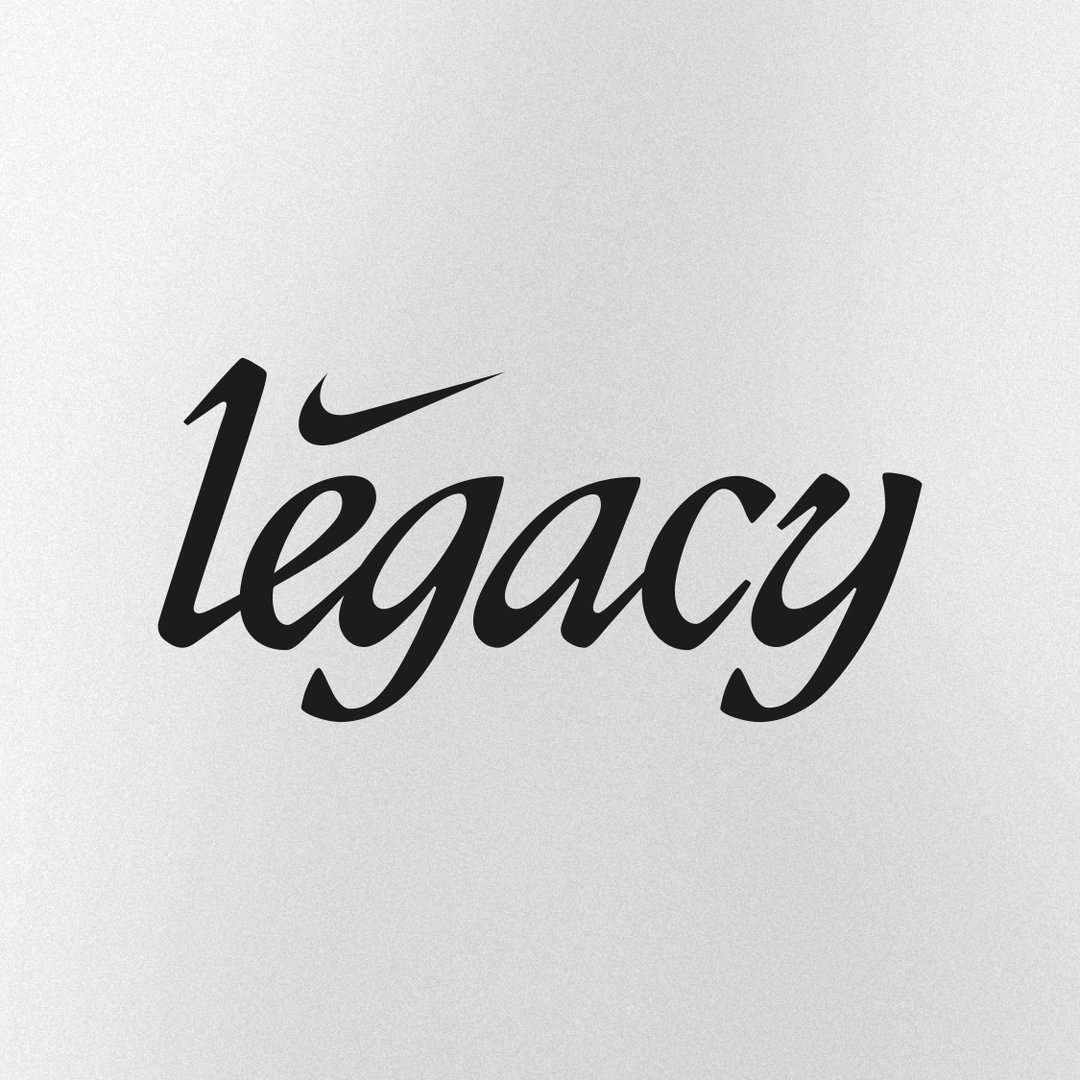 The word “legacy” is written in a black, flowing script against a light grey background. The Nike swoosh is integrated into the lettering, replacing the top of the letter “l”.